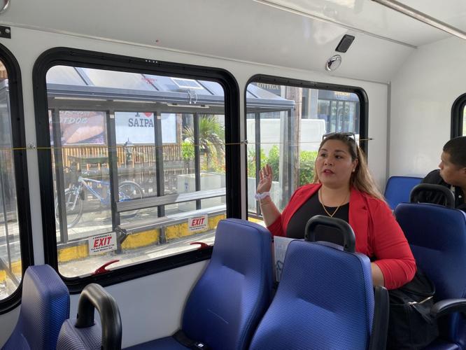 Special Assistant for Transportation Alfreda Camacho Maratita gestures as the bus stops at a bus shelter at I Love Saipan.